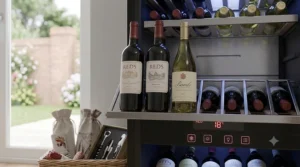 A close-up focus on the illuminated red LED temperature control display of a modern wine fridge, showing the current temperature setting.